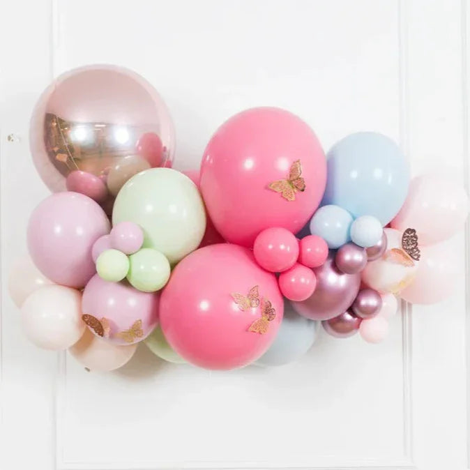 Cluster of pastel-colored birthday balloons with metallic butterfly stickers, perfect for kids' celebrations