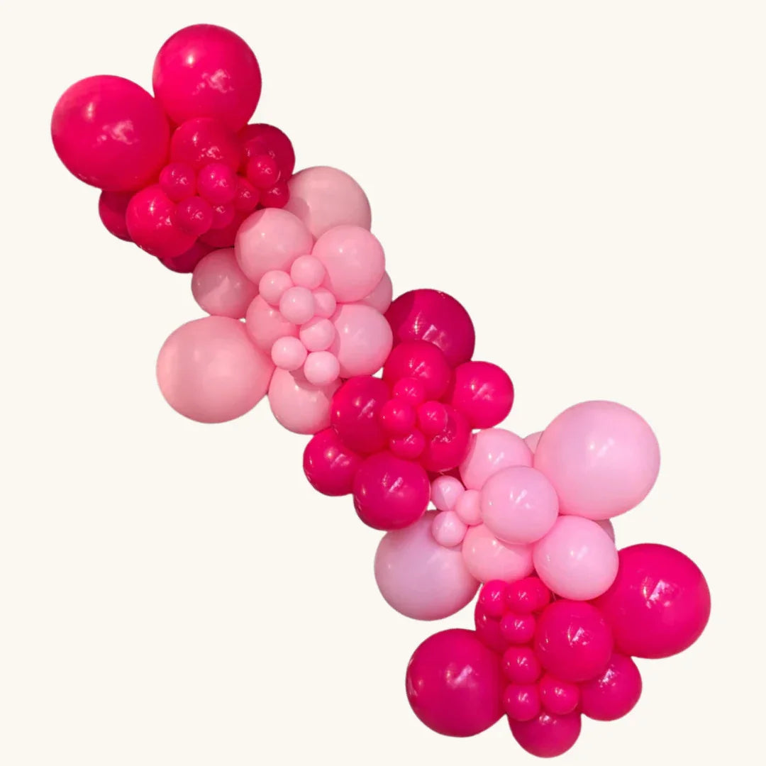 DIY garland balloon kit in bright pink and light pink balloons shaped like flowers for children's party decor